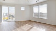 This well-appointed two-bedroom, two-bathroom residence in Denver, Colorado offers a thoughtfully designed single-level layout with modern finishes throughout. The open-concept living and dining area features light wood-style flooring, a ceiling fan, and large windows that invite abundant natural light and outdoor views, with access to a private balcony. The kitchen is a standout feature, showcasing dark espresso cabinetry, granite-style countertops, a peninsula with seating potential, stainless steel appliances, and stylish track lighting overhead. Both bathrooms are finished with wood-tone flooring, dark vanity cabinetry, and granite countertops. The primary bathroom includes a sliding glass walk-in shower with white tile surround, while the secondary bathroom offers a full tub-shower combination. The two bedrooms are carpeted and bright, each featuring windows with views of the surrounding neighborhood. The primary bedroom is generously sized with a sliding-door closet. Additional conveniences include three closets for ample storage, a dedicated laundry area, and a connecting hallway that keeps the layout organized and functional. The clean, neutral palette throughout creates a cohesive and modern living environment.