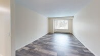 Located at 500 W Genesee St in Chittenango, NY, this thoughtfully designed 2-bedroom, 1-bathroom residence offers a comfortable and functional single-floor layout. The living room serves as the heart of the home, featuring durable hardwood-style plank flooring in a rich, varied tone and a large picture window that fills the space with natural light and offers views of the surrounding greenery. An open passage connects the living area to a dedicated dining space, also bathed in natural light.

The kitchen is well-equipped with white shaker-style cabinetry, granite-style countertops, hardwood-style flooring, and a full suite of white appliances including a refrigerator, electric range, and dishwasher — providing ample storage and workspace for everyday cooking.

Both bedrooms are finished with plush carpeting and feature sliding double-door closets for generous storage. Each room is bright and comfortable, with windows providing natural light and a calm, neutral color palette throughout.

The full bathroom is clean and functional, featuring a soaking tub with shower surround, a vanity with granite-style countertop and mirror cabinet, and tile flooring. Baseboard heating is present throughout the residence, ensuring consistent warmth year-round.