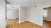 This thoughtfully designed 1-bedroom, 1-bathroom unit offers an efficient and comfortable layout across a single floor. Warm hardwood-style flooring flows consistently throughout every room, lending a cohesive and inviting feel to the entire space. Neutral light gray walls provide a clean, modern backdrop that enhances the sense of openness.

The living area is bright and airy, benefiting from large windows dressed with white plantation shutters that allow generous natural light to fill the room. The space connects smoothly to the rest of the unit, creating an easy flow for everyday living.

The kitchen is a standout feature, showcasing white shaker-style cabinetry with matte black hardware, a gray subway tile backsplash, and a classic farmhouse sink. Stainless steel appliances — including a range, over-the-range microwave, dishwasher, and refrigerator — complete the well-equipped space.

The bedroom is a comfortable, well-proportioned room featuring a ceiling fan with light fixture and windows that bring in natural light and outdoor views. The bathroom is cleanly finished with the same gray subway tile carried into a full soaking tub surround, complemented by wood-look flooring and crisp white fixtures.

Overall, this unit delivers a fresh, move-in-ready aesthetic with consistent, quality finishes throughout.