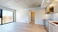 Located at 75 Slater Street in the heart of Ottawa's downtown core, this modern one-bedroom, one-bathroom unit offers a thoughtfully designed layout with contemporary finishes throughout. Light-toned hardwood flooring flows seamlessly across the entire space, complementing the crisp white walls and creating a clean, cohesive aesthetic.

A defining architectural feature is the exposed concrete ceiling, which lends an industrial character that contrasts elegantly with the otherwise bright and minimalist interior. The spacious living area is bathed in natural light through large floor-to-ceiling windows framed in sleek black, offering sweeping elevated views of the surrounding Ottawa cityscape.

The bedroom is a well-proportioned retreat, also featuring floor-to-ceiling windows that frame city views, along with a built-in sliding-door closet for practical storage. A hallway connects the living spaces to the bathroom and bedroom, providing a logical and efficient flow.

The bathroom is a standout feature, finished with large-format marble-look wall tiles, a soaking tub, and striking matte black fixtures including a rain showerhead and tub filler, giving it an upscale, spa-like feel accented by classic black-and-white hexagon mosaic floor tiles.

The unit's position in the building offers prominent views over downtown Ottawa, making it an ideal urban residence.