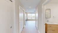 Located at 922 N Broad St in Philadelphia's vibrant Northern Liberties neighborhood, this efficiently designed single-floor unit offers a thoughtfully organized layout that maximizes every square foot. Light hardwood-style flooring flows throughout, complementing the clean, neutral palette of warm beige walls and crisp white trim.

The combined kitchen and living area serves as the heart of the unit, anchored by a large picture window that floods the space with natural light and offers open city views. The kitchen is outfitted with light natural wood cabinetry extending to the ceiling, a white tile backsplash, and a full suite of stainless steel appliances including a gas range, built-in microwave, refrigerator, and dishwasher.

A central hallway connects the remaining spaces, lined with two closets offering ample storage. The bathroom features marble-style tile flooring, a light wood vanity, and clean white walls, maintaining the modern aesthetic found throughout. A dedicated laundry area and utility room add practical convenience to the unit.

Recessed lighting and a ceiling-mounted HVAC system ensure comfort year-round. The overall design is clean, contemporary, and move-in ready, making this unit a well-appointed option in one of Philadelphia's most dynamic urban corridors.