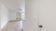 This contemporary 940 square foot apartment offers a thoughtful layout with 2 bedrooms and 2 bathrooms. The open-concept living area seamlessly combines the kitchen and living room, creating a spacious feel. Large windows and sliding glass doors flood the space with natural light and provide access to an outdoor patio. The kitchen boasts white cabinetry, granite countertops, and stainless steel appliances, complemented by a functional island. Wood-look tile flooring unifies the space throughout. The primary bedroom, measuring 180 square feet, features a ceiling fan and ample closet space. Both bathrooms are well-appointed with modern fixtures. Additional amenities include in-unit laundry facilities and multiple closets for storage. The apartment's clean lines, neutral color palette, and abundance of natural light create a bright and airy ambiance, perfect for contemporary living in Orlando, Florida.