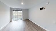 Located in the desirable 90046 zip code of Los Angeles, this thoughtfully renovated single-floor residence at 1538 N Vista St showcases a clean, modern aesthetic throughout. Light gray walls and warm luxury vinyl plank flooring run continuously across the space, creating a cohesive and inviting atmosphere.

The open-concept living area is bathed in natural light from large sliding glass doors that open to an outdoor view of lush greenery, complemented by recessed lighting and a wall-mounted climate control unit. A striking floor-to-ceiling mirrored wall visually expands the space and adds a refined touch.

The kitchen is well-appointed with white shaker cabinets, quartz countertops, a mosaic tile backsplash, and stainless steel appliances including a gas range and over-the-range microwave. A double-basin stainless steel sink anchors the kitchen workspace.

Bedrooms feature the same hardwood-style flooring and soft neutral tones, with windows offering pleasant neighborhood views. A hallway connects the living spaces to the bedrooms and bathrooms with ease.

The bathrooms are finished with tile-surround tub/shower combinations, stone-look tile walls, white vanities with quartz counters, and brushed nickel fixtures — delivering a spa-like feel with clean, contemporary design throughout.