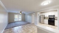 Located at 3280 Silver Springs Dr in Louisville, KY, this well-maintained 2-bedroom, 2-bathroom single-floor home offers a comfortable and functional layout. The living room features a combination of light-toned tile flooring and plush carpet, accented by crown molding and a ceiling fan, with French doors that open to an outdoor balcony, filling the space with natural light. The kitchen is equipped with white cabinetry, granite-style countertops, and stainless steel appliances including a refrigerator, microwave, and electric range, complemented by a dishwasher and tile flooring throughout. The primary bedroom is a well-proportioned retreat with soft carpet, a ceiling fan with light fixture, and a window that brings in natural light. The second bedroom similarly offers carpeted floors and a natural light source. Both bathrooms are finished with tile flooring, white vanities topped with granite-style countertops, and framed mirrors. One bathroom features a walk-in shower, while the other includes a vanity with stylish black hardware and lighting fixtures. Hallways connect the rooms efficiently, and a dedicated closet adds practical storage. Neutral tones throughout create a clean, cohesive ambiance.