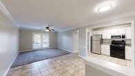 Located at 3280 Silver Springs Dr in Louisville, KY, this well-maintained 2-bedroom, 2-bathroom single-floor home offers a comfortable and functional layout. The living room features a combination of light-toned tile flooring and plush carpet, accented by crown molding and a ceiling fan, with French doors that open to an outdoor balcony, filling the space with natural light. The kitchen is equipped with white cabinetry, granite-style countertops, and stainless steel appliances including a refrigerator, microwave, and electric range, complemented by a dishwasher and tile flooring throughout. The primary bedroom is a well-proportioned retreat with soft carpet, a ceiling fan with light fixture, and a window that brings in natural light. The second bedroom similarly offers carpeted floors and a natural light source. Both bathrooms are finished with tile flooring, white vanities topped with granite-style countertops, and framed mirrors. One bathroom features a walk-in shower, while the other includes a vanity with stylish black hardware and lighting fixtures. Hallways connect the rooms efficiently, and a dedicated closet adds practical storage. Neutral tones throughout create a clean, cohesive ambiance.