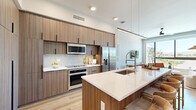 Located at 7450 N Uptown Dr in Tucson, AZ, this thoughtfully designed 2-bedroom, 3-bathroom residence offers a seamless blend of modern aesthetics and functional living. Light-toned hardwood flooring flows throughout, unifying each space with warmth and continuity.

The open-concept kitchen is a standout feature, showcasing floor-to-ceiling wood-grain cabinetry with sleek black hardware, white quartz countertops, stainless steel appliances, and a peninsula with bar seating — ideal for both casual dining and entertaining. The adjoining living room is bathed in natural light through large picture windows that frame sweeping views of the Tucson landscape, complemented by ceiling fans and a clean, neutral palette.

The primary bedroom is generously proportioned, offering direct access to a private closet and a well-appointed en-suite bathroom featuring a floating dual vanity with modern fixtures and a glass-enclosed shower. A second bedroom enjoys abundant natural light and outdoor views through its own large window. Two additional closets provide ample storage throughout the residence.

Three full bathrooms ensure convenience for residents and guests alike. Clean lines, recessed lighting, and a consistent modern design language create a cohesive, sophisticated ambiance throughout this well-appointed Tucson home.