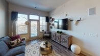 This single-floor residence offers a thoughtfully designed open-concept layout that seamlessly connects the kitchen, dining, and living areas. The kitchen is a standout feature, equipped with dark espresso cabinetry, granite countertops, stainless steel appliances — including a refrigerator, dishwasher, and built-in microwave — and a large central island with pendant lighting overhead, ideal for casual dining or entertaining. Wood-style flooring runs throughout the main living areas, adding warmth and continuity to the space.

The living room receives generous natural light through large windows, creating a bright and welcoming atmosphere. It offers comfortable proportions with enough room for a full seating arrangement.

The bedroom is a calm retreat, featuring plush carpeting, a large window with blinds, and access to a generously sized walk-in closet outfitted with multiple hanging rods and shelving on three walls, providing ample storage.

The bathroom continues the home's refined aesthetic with granite countertops, dark cabinetry, wood-style flooring, and direct access to the walk-in closet for added convenience.

Overall, the space balances modern design with functional living, highlighted by consistent finishes, recessed lighting, and an open, airy feel throughout.