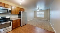 Located at 860 S 68th St in West Des Moines, Iowa, this one-bedroom, one-bathroom home is thoughtfully arranged across three floors. The ground level houses a private attached garage with an automatic opener and a concrete floor, providing secure and convenient parking. Carpeted staircases connect each level, with clean white railings guiding the way through the home.

The main living floor features an open-concept layout where the kitchen flows directly into the living area. The kitchen is equipped with warm honey-toned cabinetry, granite-style countertops, and a full suite of stainless steel appliances including a refrigerator, electric range with microwave above, and dishwasher. Durable hardwood-style flooring runs throughout the kitchen, transitioning to carpet in the adjacent living space, which is brightened by a window and finished with a ceiling fan.

The upper floor is home to the spacious primary bedroom, featuring plush carpeting, a tray ceiling with ceiling fan, a sliding double-door closet, and a bright window overlooking the surrounding neighborhood. The full bathroom is finished with large-format tile flooring, a rich cherry wood vanity with ample storage, a framed mirror, and a window for natural light. The hallway provides convenient access between the bedroom and bathroom, completing this well-organized and functional layout.