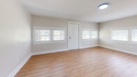 This two-story home offers a thoughtfully designed layout spread across two floors, combining functional living spaces with clean, modern finishes. The main level features a welcoming entrance with warm hardwood-style luxury vinyl flooring that carries through the living areas and kitchen. Two distinct living spaces provide flexibility for everyday living and entertaining. The kitchen is a standout highlight, outfitted with crisp white shaker cabinetry, matte black hardware, light quartz countertops, a farmhouse sink, and a full suite of stainless steel appliances including a dishwasher and refrigerator. Multiple windows dressed with wood-tone blinds fill the main floor with natural light and offer pleasant outdoor views. The upper level hosts two bedrooms, including a generously sized primary bedroom, both featuring plush carpeting and ample natural light. The full bathroom is finished with grey subway tile surround in the tub-shower combo, matte black fixtures, a window for ventilation, and warm hardwood-style flooring. A hallway and staircase connect the two floors seamlessly. Throughout, neutral warm-toned walls and clean white trim create a cohesive, move-in ready aesthetic.