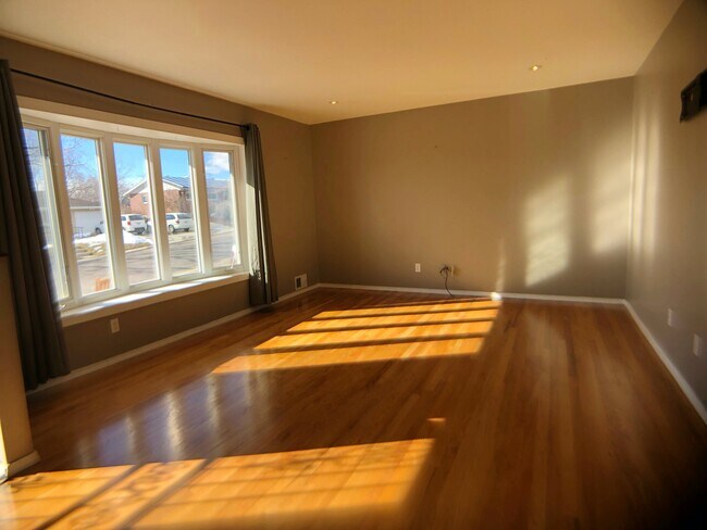 Sunny living area highlighted with hardwoods & huge bay windows! - 2730 S Utica St