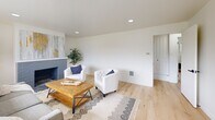 Located at 3732 N Stevens St in Tacoma, WA, this two-story home offers a thoughtfully designed layout spread across two floors. Light hardwood flooring flows throughout, complementing the clean, neutral palette that defines the interior aesthetic.

The main floor hosts the primary living and entertaining areas. The living room is anchored by a painted brick fireplace and large panoramic windows that frame views of the surrounding tree line, filling the space with natural light. Recessed lighting adds to the bright, open ambiance. The adjacent dining area features a modern sputnik-style chandelier and its own wide picture window overlooking greenery, creating an inviting atmosphere for meals. The kitchen is outfitted with warm wood cabinetry, white countertops, stainless steel appliances, and a window above the sink.

Upstairs, three bedrooms offer comfortable retreats, each with generous windows providing neighborhood views and natural light. The primary bedroom is a well-proportioned space with dual windows. Two bathrooms serve the home—one featuring dark tile surround, a soaking tub, and gold fixtures, while the second is clean and functional. A dedicated exercise room adds versatile utility, rounding out a practical and well-balanced floor plan.