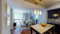 Located on the 13th floor at 4918 St Elmo Ave in Bethesda, MD, this contemporary apartment offers a well-designed, open-concept layout bathed in natural light. The living and dining area flows seamlessly together, anchored by rich hardwood flooring, floor-to-ceiling windows, and a balcony that frames impressive city views. Pendant lighting over the dining space and a sunburst mirror accent wall add refined touches to the living area.

The gourmet kitchen is appointed with dark espresso cabinetry, granite countertops, stainless steel appliances, and a central island that doubles as a breakfast bar — ideal for both cooking and entertaining.

The apartment features two well-proportioned bedrooms. The primary bedroom offers a serene retreat with warm neutral tones, plush carpeting, and a stylishly framed bed. The secondary bedroom enjoys large windows with sweeping views of the Bethesda skyline and surrounding greenery. Both rooms benefit from generous natural light.

The bathroom is finished with large-format tile flooring, a dark vanity with granite counters, and a glass-enclosed walk-in shower. Throughout the apartment, the design balances modern urban aesthetics with comfortable, livable warmth.