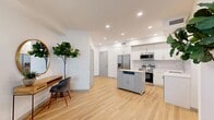 Located at 14817 Foothill Blvd in Fontana, CA, this thoughtfully designed one-bedroom, one-bathroom residence offers a bright and modern living experience across a single floor. Light wood-tone flooring flows throughout, complementing the clean white walls and recessed lighting that give the space an airy, contemporary feel.

The open-concept kitchen is a standout feature, equipped with full stainless steel appliances including a side-by-side refrigerator, range, microwave, and dishwasher. Crisp white cabinetry with a subtle tile backsplash lines the walls, while a freestanding island with a butcher block top provides additional prep space and storage. The kitchen opens seamlessly into the living area, which benefits from generous natural light through large windows and direct access to a private balcony.

The bedroom is a comfortable and quiet retreat, featuring a window with exterior views and ample natural light. Two closets serve the unit, including a spacious walk-in with wire shelving. The bathroom is clean and modern, outfitted with a white vanity, backlit mirror, and built-in open shelving. A dedicated laundry area and hallway complete the well-organized floor plan, making this unit as functional as it is stylish.