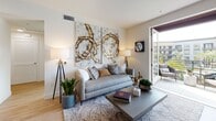 Located in the vibrant Civita community of San Diego, this well-appointed single-floor residence offers a thoughtfully designed layout with modern finishes throughout. The kitchen is a standout feature, showcasing floor-to-ceiling white cabinetry, stainless steel appliances including a gas range, microwave, dishwasher, and refrigerator, complemented by a warm tile backsplash, quartz countertops, and light wood-style flooring that flows seamlessly through the common areas. A dedicated dining area with a marble-topped table sits beneath contemporary framed artwork, creating an intimate space for meals and entertaining. The living room is bright and welcoming, with access to a private outdoor balcony that brings in natural light and views of the surrounding community. Two well-sized bedrooms feature plush carpeting and large windows that frame outdoor views of the Civita neighborhood's lush landscaping. The bathrooms are clean and modern, with white tilework, soaking tubs, and ample vanity storage. Light wood-style flooring extends through the hallways and bathrooms, maintaining a cohesive aesthetic. A convenient in-unit stacked washer and dryer adds to the functionality of this well-designed residence, making it an ideal home in one of San Diego's most dynamic communities.