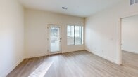Located at 105 S Main St in Layton, Utah, this thoughtfully designed one-bedroom, one-bathroom unit offers a modern, open-concept layout with a clean, contemporary aesthetic throughout. Light wood-style plank flooring flows seamlessly across the entire space, complementing the bright white walls and creating a cohesive, inviting atmosphere.

The kitchen serves as a central highlight, featuring a large center island with a crisp white countertop and sleek gray cabinetry. A full suite of stainless steel appliances—including a gas range, built-in microwave, dishwasher, and refrigerator—lines the back wall, accented by a white tile backsplash. Pendant lighting above the island adds a stylish finishing touch, while recessed ceiling lights provide ample illumination.

The open living area flows naturally from the kitchen and benefits from natural light through a windowed exterior door and adjacent window. The bedroom is a well-proportioned, quiet retreat with a dedicated window and direct access to the bathroom hallway.

The bathroom features a wide vanity with gray cabinetry, a white countertop, a large mirror, and brushed nickel fixtures. An adjacent closet provides convenient storage. The layout is efficient and functional, making excellent use of the available floor area while maintaining a spacious, uncluttered feel throughout.