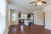 Located at 505 Cap Stone Arch in Chesapeake, Virginia, this single-floor residence offers a well-designed layout that balances comfort and functionality. The open-concept living and dining area is highlighted by rich hardwood flooring, a ceiling fan with light fixture, and an elegant arched passageway that adds architectural charm. Multiple windows flood the space with natural light and provide views of the surrounding neighborhood.

The kitchen is a standout feature, equipped with dark espresso cabinetry, granite countertops, a classic subway tile backsplash, and a full suite of stainless steel appliances including a refrigerator, range, and built-in microwave. A kitchen island provides additional prep space and flows naturally into the living area.

The bedrooms are carpeted for comfort, offering a quiet retreat. One bedroom benefits from windows overlooking greenery outside. The bathrooms are finished with tile flooring, dark vanity cabinetry, and tub-shower combinations featuring full tile surrounds.

A dedicated laundry room with hardwood flooring houses a full-size washer and dryer with overhead shelving for storage. Throughout the residence, a neutral color palette and consistent finishes create a cohesive and move-in ready environment.