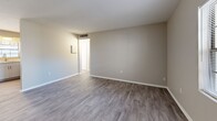 Located in Tampa, FL, this 2-bedroom, 1-bathroom unit offers a practical and well-organized single-floor layout. The combined kitchen and living area serves as the heart of the home, with durable wood-look flooring running throughout. The kitchen is equipped with white shaker-style cabinetry, light stone countertops, a tile backsplash in warm earth tones, and black appliances including a range and stainless-style refrigerator. A nearby window allows natural light to brighten the dining and kitchen space.

The living room provides a comfortable, open area with neutral beige walls, wood-look flooring, and a window facing the exterior. Both bedrooms are carpeted for added comfort and feature neutral walls, windows that bring in natural light, and standard closet access. The primary bedroom offers a generous footprint with two windows providing views of the surrounding greenery. The second bedroom also includes a window and connects easily to the shared hallway.

The bathroom includes a full tub-shower combination with white tile surround and a window for natural ventilation. A dedicated hallway with a closet adds storage convenience. The overall aesthetic is clean and neutral, making the space move-in ready.