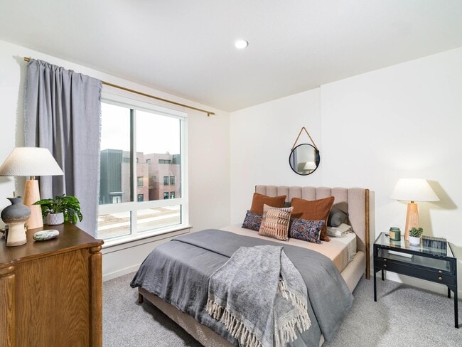 A serene bedroom retreat at Modera University Park, pairing soft finishes and natural light with a location close to University Park’s dining and culture. - Modera University Park