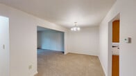 Located at 1011 Hughes Dr in Trenton, NJ, this single-floor, two-bedroom, one-bathroom home offers a practical and well-organized layout. The living room features neutral carpeting and clean white walls, providing a bright and open feel. Three hallways connect the key areas of the home, ensuring smooth circulation throughout.

The kitchen is equipped with warm honey-toned wood cabinetry, ample counter space, a white electric range, a dishwasher, and a full-size refrigerator topped with matching upper cabinets. Light tile flooring and a large window allowing natural light make the kitchen an inviting functional space.

The spacious primary bedroom is generously sized, carpeted in a neutral tone, and features a window with outdoor views, a closet, and an adjacent room entry. The second bedroom is similarly finished with carpet flooring, white walls, a window, and a closet, offering comfortable and versatile use.

The bathroom is well-appointed with warm beige tile wainscoting, tile flooring, a wood-toned vanity with a white countertop, a toilet, and a tub-shower combination with a tiled surround. A window provides natural ventilation and light. Throughout the home, a consistent neutral palette and carpeted bedrooms create a clean, move-in ready atmosphere.