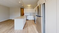 Located at 12 Auburndale Crt in Toronto's M9W neighbourhood, this two-storey home offers a well-organized layout across two floors. The main floor hosts the primary living spaces, including a bright combined dining and living area with large windows that invite natural light and provide views of the fenced outdoor space. The modern kitchen is a standout feature, equipped with stainless steel appliances — including a refrigerator, stove, built-in microwave, and dishwasher — white shaker-style cabinetry, stone countertops, a subway tile backsplash, and a central island, all set atop light-toned laminate flooring. A dedicated entrance and multiple hallways ensure smooth flow throughout. The upper floor contains both bedrooms, including a generously sized primary bedroom with a double-door closet and warm hardwood floors. A stacked washer and dryer unit is conveniently accessible from the bedroom level. The two bathrooms are finished in a clean, contemporary style — one featuring a glass-enclosed walk-in shower with subway tile surround, and the other with a tub-shower combination and stone-topped vanity. With five closets spread throughout and a private exterior yard, this home offers practical storage and outdoor living space.
