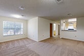 Located at 1101 Cobblestone Circle in Kissimmee, Florida, this single-story, 3-bedroom, 2-bathroom home offers a practical and well-organized layout. The open-concept living and dining area is finished with wall-to-wall carpet and features a textured ceiling, neutral white walls, and windows that bring in natural light. A pendant light fixture marks the transition into the dining space, which flows directly into the kitchen. The kitchen features wood-toned cabinetry, a dark countertop, and a pass-through overlooking the living area. A hardwood-style hallway connects the main living spaces to the bedrooms and utility areas, with built-in access panels visible along the corridor. Each of the three bedrooms is carpeted, with neutral walls and windows providing natural light and outdoor views of the surrounding greenery. Closets are provided in each bedroom, offering ample storage. The primary bedroom is a comfortable, well-proportioned space. Both bathrooms are finished with white tile surrounds, tub-shower combinations, and one features wood-toned cabinetry with a single-basin vanity and light wood-style flooring. A dedicated utility room completes the functional layout of this straightforward Kissimmee home.