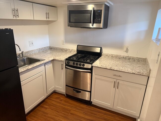 Full kitchen with refrigerator, microwave and gas range - 4020 Blaine St NE
