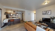 Located at 12007 E Coyote Rock Dr in Spokane Valley, WA, this single-floor residence offers a thoughtfully designed open-concept layout that seamlessly connects the living, dining, and kitchen areas. The living room is bright and welcoming, featuring wood-look flooring, large windows that invite natural light, and a door providing outdoor access.

The kitchen is well-appointed with dark espresso cabinetry, light quartz countertops, stainless steel appliances including a refrigerator, range, and built-in microwave, and wood-look flooring that carries throughout the main living spaces. A kitchen island with pendant lighting adds both functionality and style.

The bedrooms offer plush carpeting and generous closet space. The primary suite includes a walk-in closet with wire shelving and an en-suite bathroom with a dark vanity and wood-look tile flooring. A secondary bedroom serves well as a home office or guest room, complete with a sliding closet. The full bathroom features a tub-shower combination and coordinating tile flooring.

A dedicated in-unit laundry area accommodates a full-size washer and dryer. The consistent use of dark trim, neutral tones, and modern finishes throughout gives this residence a cohesive, contemporary aesthetic.