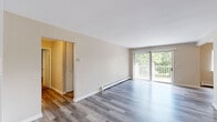 Located at 908 Ridge Square in Elk Grove Village, IL, this well-appointed two-bedroom, two-bathroom residence offers a comfortable and functional single-floor layout. The open living room is bright and airy, showcasing light-toned hardwood-style flooring, neutral walls, and a sliding glass door that leads to a private balcony with lush outdoor views — an ideal extension of the living space. A ceiling fan and baseboard heating provide year-round comfort throughout the main living area. The combined dining room and kitchen features a peninsula counter that creates a natural divide between spaces, complemented by white cabinetry, stainless steel appliances including a refrigerator and range, and warm hardwood-style flooring. Both bedrooms offer plush carpeting and generous closet space — six closets are distributed throughout the residence, ensuring ample storage. The primary bedroom is spaciously sized, providing room for a full suite of furnishings. The two bathrooms are finished with clean white cabinetry, light-toned flooring, and crisp fixtures. A hallway connects the private areas of the home efficiently. Overall, the residence maintains a clean, neutral aesthetic that offers a welcoming and move-in-ready environment.