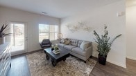 This single-floor residence offers a thoughtfully designed layout with a cohesive neutral palette and modern finishes throughout. The living room serves as a central gathering space, featuring dark hardwood-style flooring, a large window that invites natural light, and ample room for comfortable seating arrangements. Adjacent to it, the dining area provides an intimate setting with the same wood-style flooring and stylish wall accents.

The galley-style kitchen is well-equipped with dark espresso cabinetry, marble-look countertops, stainless steel appliances including a range, microwave, and refrigerator, and a double sink. Wood-look flooring ties the space together seamlessly.

Both bedrooms are carpeted and ceiling fan-equipped. The primary bedroom is generously sized with a large window, while the second bedroom offers a cozy, functional layout. Each room benefits from a calm, neutral color scheme.

Two full bathrooms mirror the kitchen's design aesthetic, featuring dark espresso vanities with marble-look countertops. One bathroom includes a shower with a curtain rod, while the other offers a full soaking tub. Both feature wood-look tile flooring.

A dedicated laundry room with a full-size washer and dryer and overhead shelving rounds out this well-organized residence.