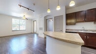 Located at 2900 Wildflower Dr in Bryan, Texas, this single-story, three-bedroom, two-bathroom home offers a functional and well-appointed layout. The open-concept kitchen and living area serves as the heart of the home, featuring rich dark wood cabinetry, a full suite of black appliances including a refrigerator, range, and built-in microwave, as well as a curved breakfast bar with pendant lighting overhead. Track lighting and a ceiling fan complement the space, while wood-style flooring runs throughout the main living areas, adding warmth and continuity. The living room benefits from natural light through a large window and a glass-panel door that opens to the outdoors. The three bedrooms are carpeted and each include a ceiling fan and window with outdoor views. The primary bedroom provides a comfortable, well-sized retreat. Both bathrooms mirror each other in design, each offering a vanity with dark wood cabinetry, a light countertop, and a tub-shower combination. Wood-style flooring carries through both bathrooms, tying the aesthetic together. The home also includes a dedicated laundry area, a closet, a hallway, and an entrance, making for a complete and practical living experience.