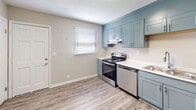 Located at 526 Carl St. in Gastonia, North Carolina, this two-floor home offers a well-maintained and thoughtfully updated interior. The main living area is finished with durable wood-look hard surface flooring and a textured ceiling, creating a clean and contemporary feel. Natural light filters in through blinded windows, brightening the open space, which is complemented by a ceiling fan for added comfort.

The kitchen is a standout feature, showcasing stylish blue-gray shaker-style cabinetry with brushed nickel hardware, light quartz countertops, and a full suite of stainless steel appliances including a refrigerator, electric range, and dishwasher. A double-basin sink with a modern pull-down faucet completes the functional layout, and a window above the range area allows for natural ventilation and light.

The bedrooms are carpeted for warmth and comfort, each equipped with a ceiling fan and windows that invite in natural light. The layout provides a sense of privacy and ample room for furnishing. The bathroom features a clean white vanity with a framed mirror and brushed nickel fixtures, alongside a full tub-shower combination. Throughout the home, neutral tones and consistent finishes create a cohesive and inviting atmosphere.