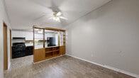Located at 8213 Highway 85 in Riverdale, Georgia, this single-floor, one-bedroom, one-bathroom home offers an efficient and well-organized layout. The living room is a welcoming space featuring light-toned luxury vinyl plank flooring, neutral gray walls, a textured ceiling, and a ceiling fan with light fixture. A standout architectural element is the built-in wood room divider with open shelving and lower cabinet storage, which visually separates the living area from the kitchen while maintaining an open, connected feel.

The kitchen is equipped with white cabinetry, a mosaic tile backsplash, a sink, black appliances including a range and refrigerator, and a ceiling fan. A window with blinds allows natural light into the space. The bedroom is a comfortable, well-proportioned room with the same LVP flooring, a window overlooking the outdoors, a textured ceiling, and a wood-trimmed bi-fold closet door. Two closets provide ample storage throughout the home.

The full bathroom features a tub/shower combo, toilet, and a single-sink vanity with white cabinetry. A dedicated laundry area houses the water heater and utility connections. Wood-trimmed interior doors and consistent flooring throughout unify the home's cohesive, functional design.