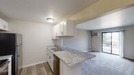 Located at 5340 Kellogg Woods Dr SE in Kentwood, Michigan, this single-floor unit offers a thoughtfully designed layout with modern updates throughout. The kitchen serves as a functional centerpiece, featuring granite countertops, white shaker-style cabinetry, and stainless steel appliances including a refrigerator, range, and dishwasher. Wood-look vinyl flooring runs through the kitchen area, adding warmth and durability, while a peninsula counter provides a natural transition into the adjoining living space.

The living room is carpeted and well-proportioned, with a wall-mounted air conditioning unit and a sliding glass door that opens to a private balcony, allowing for natural light and outdoor views. The open connection between the kitchen and living area creates a cohesive, easy-flowing layout suited for everyday living.

The bedroom is carpeted and features a window that brings in natural light, maintaining a calm and comfortable atmosphere. The bathroom is clean and efficiently arranged, with a granite-topped vanity with white cabinetry, a framed mirror, and a full tub-shower combination. Wood-look flooring ties the bathroom's aesthetic to the rest of the unit. Overall, the space presents a consistently updated interior with neutral tones and practical finishes throughout.