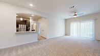 This single-floor residence offers a thoughtfully designed open-concept layout that seamlessly connects the living, dining, and kitchen areas. The living room is generously sized, featuring plush wall-to-wall carpeting, a ceiling fan, and access to a private outdoor area through a sliding glass door framed by vertical blinds that allow an abundance of natural light to fill the space.

The kitchen is accessible through a graceful arched opening and is equipped with stainless steel appliances, including a refrigerator, range, microwave, and dishwasher. Dark wood cabinetry with sleek hardware is complemented by granite-style countertops, a white subway tile backsplash, and light hardwood flooring, creating a clean, modern aesthetic. A breakfast bar provides additional seating and serves as a practical divider between the kitchen and living area, with pendant lighting adding a refined touch.

The bedroom is a comfortable retreat, offering plush carpeting, a ceiling fan, and a large window that invites natural light and outdoor views. It includes access to a spacious walk-in closet outfitted with multi-tiered wire shelving and built-in shelves for ample storage.

The bathroom features light wood-look tile flooring, a granite-topped dark wood vanity, and a full tub-shower combination, all finished in a clean, contemporary style.
