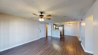 This single-floor, 2-bedroom, 2-bathroom residence in Gulfport, Mississippi offers a well-organized layout designed for comfortable everyday living. The open living area features rich, dark hardwood-style flooring, neutral gray walls, a textured ceiling, and a ceiling fan with light fixture. French doors provide direct access to the outdoors, allowing natural light to fill the space. A second living or flex area is accessible through the main living room and shares the same flooring and ceiling fan details.

The kitchen is positioned at the heart of the home and features a peninsula with a sink and light stone countertops, gray cabinetry, white appliances including a refrigerator and range, and overhead fluorescent lighting. The kitchen flows seamlessly into the main living area, making it ideal for entertaining.

Both bedrooms are carpeted and include ceiling fans with light fixtures, neutral walls, and textured ceilings. Each bedroom offers ample space and natural light from windows. The two bathrooms are outfitted with dark vanity cabinetry, light stone countertops, and tub-shower combinations. Wood-style flooring in the bathrooms complements the overall design aesthetic. The home's cohesive neutral palette and practical layout make it a functional and inviting residence.