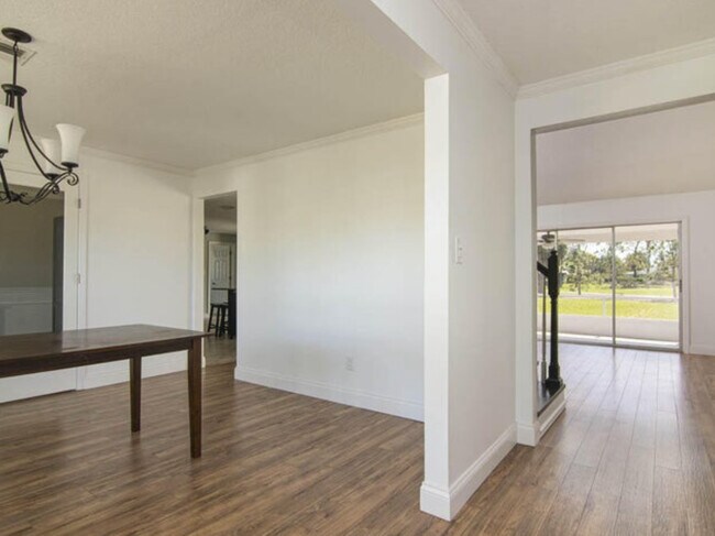 Main hallway leads to dining room, vaulted grand living room with stone fireplace, stairs, bedrooms+ - 541 Inverness Ave