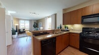 Located at 610 E Union St in Pasadena, California, this single-floor residence offers a thoughtfully designed open-concept layout with modern finishes and a cohesive aesthetic throughout. The kitchen is a standout feature, equipped with rich warm-toned wood cabinetry, granite countertops, a peninsula with an integrated dishwasher, a double-basin sink, and a full suite of black appliances including a gas range, microwave, and refrigerator. Under-cabinet lighting adds a refined touch to the workspace. The kitchen flows seamlessly into the living and dining area, which is bathed in natural light from large windows dressed with elegant drape panels. The living room offers scenic views of the surrounding Pasadena cityscape and distant mountains, enhancing its bright and inviting ambiance. Wood-look flooring runs consistently throughout the space, adding warmth and visual continuity. The bedroom is a serene retreat, highlighted by a bold teal accent wall, ample natural light, and a spacious walk-in closet with multi-tier shelving. A dedicated desk area within the bedroom provides a functional workspace. The bathroom features a wide vanity with generous counter space, a large mirror, wood-toned cabinetry, and a combination shower and tub. The overall design balances contemporary style with comfortable, practical living.