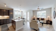 This well-designed single-floor residence offers a thoughtfully planned open-concept layout that seamlessly connects the main living areas. The kitchen is a standout feature, showcasing dark cabinetry with brushed hardware, a white quartz countertop island with an undermount sink, stainless steel appliances including a refrigerator, range, and built-in microwave, and a classic white subway tile backsplash. Track lighting and pendant lights above the island add both function and style.

Adjacent to the kitchen, the dining area is bathed in natural light from multiple large windows and a glass-paneled door, with light wood-look flooring throughout. The living room provides a comfortable, airy atmosphere with a ceiling fan, large windows fitted with horizontal blinds, and ample space for relaxed seating arrangements.

The bedroom is a serene retreat, featuring plush carpet, a ceiling fan, and a window that invites natural light. A spacious walk-in closet connects to the en suite bathroom, which is finished with large-format tile flooring, a dual-sink vanity with white cabinetry, and a separate tub and shower area. A secondary bathroom offers similar clean finishes with tile flooring, a single vanity, and a tub-shower combination. Throughout, neutral tones and clean architectural lines create a cohesive, modern ambiance.