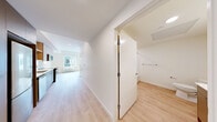 Located at 4001 198th St SW in Lynnwood, WA, this thoughtfully designed one-bedroom, one-bathroom unit offers a clean, modern aesthetic throughout its efficiently laid-out single floor. Light wood-tone flooring flows seamlessly through the living areas, hallway, and bedroom, lending warmth and continuity to the space.

The kitchen stands out with its contemporary design, featuring flat-front cabinetry in a two-tone palette of light wood upper shelving and soft gray lower cabinets. White quartz countertops, a deep stainless steel undermount sink with a sleek pull-down faucet, a subway tile backsplash, and stainless steel appliances — including a range and over-the-range microwave — complete the well-appointed cooking space.

The living area is accented by sliding panel doors in a clean white finish, offering a modern, space-conscious design detail. The bedroom benefits from generous natural light provided by a large multi-pane window with views of the surrounding neighborhood, complemented by a stylish circular ceiling light fixture.

The bathroom offers a full soaking tub and shower combination with white tiled surround, built-in corner shelving, and a brushed nickel towel bar, maintaining the unit's clean and minimal design language throughout. Overall, the space presents a bright, modern, and efficiently organized home.