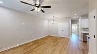 Located at 110 Peach Blossom Rd in Warner Robins, Georgia, this single-story, 3-bedroom, 2-bathroom home offers a thoughtfully designed layout with modern finishes throughout. Warm, honey-toned hardwood-style flooring flows consistently across the main living areas and bedrooms, creating a cohesive and inviting atmosphere.

The open living room is bright and airy, featuring a ceiling fan with a light fixture and a stylish pendant chandelier, complemented by recessed lighting. Double doors add an elegant touch to the space. The kitchen is well-appointed with white shaker-style cabinetry, quartz countertops, stainless steel appliances including a range, microwave, refrigerator, and dishwasher, and a black matte sink fixture — a clean, functional space ideal for everyday cooking.

The primary bedroom offers a comfortable sense of space, with a ceiling fan, natural light from a window with blinds, and direct access to the outdoors. The two additional bedrooms are similarly finished, each with ceiling fans and windows allowing natural light. Both bathrooms are finished with light tile flooring, quartz-topped vanities with gray cabinetry, black matte hardware, and a tub-shower combination. The home also includes two closets and a connecting hallway, rounding out a practical and polished floor plan.