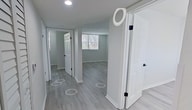 This 540 square foot apartment in Miami offers a practical and contemporary living space. The single-story layout comprises three bedrooms, including a generous primary bedroom of 250 square feet, one bathroom, and a kitchen. Throughout the apartment, modern wood-look flooring creates a cohesive and stylish appearance.

The bathroom features a clean, white design with a combination tub-shower, modern fixtures, and ample lighting. Bedrooms are well-proportioned, with large windows allowing natural light to flood the spaces. Built-in closets provide essential storage solutions.

The kitchen, while compact, is efficiently designed with sleek white cabinetry, stainless steel appliances, and a practical layout. The apartment's neutral color palette, dominated by whites and light grays, contributes to a bright and airy atmosphere.

Windows in various rooms offer views of the surroundings and natural light, enhancing the sense of space within the compact floor plan. The overall design prioritizes functionality and modern aesthetics, making efficient use of the available square footage.
