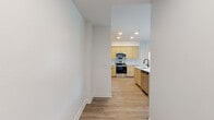 Located at 4041 Radford Ave in the heart of Studio City, California, this modern single-story unit delivers a clean, contemporary aesthetic throughout. The open-concept layout seamlessly connects the living area to the kitchen, which serves as a standout feature of the space. The kitchen is outfitted with flat-front light wood cabinetry extending to the ceiling for ample storage, a geometric-patterned tile backsplash, white quartz countertops, a central island with a built-in sink, and a full suite of stainless steel appliances including a French door refrigerator, range, microwave, and dishwasher. Pendant lighting adds a modern touch above the island. The spacious living area is bathed in natural light through large windows with views of surrounding greenery, and light wood-tone flooring flows consistently throughout the entire unit. The bedrooms are generously proportioned, each featuring windows with natural light and ceiling fans. The bathrooms echo the same modern design language — one features a round mirror, warm wood vanity with black hardware, and white countertops, while the second offers a clean tub-shower combination with matte black fixtures. The overall ambiance is bright, fresh, and move-in ready.