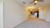 Located at 10207 Dwell Court in Orlando, FL, this 2-bedroom, 1-bathroom home offers a thoughtfully designed single-floor layout that maximizes comfort and functionality. The open-concept living and dining area features plush carpeting, neutral tones, and a ceiling fan, creating a relaxed and inviting atmosphere. Pendant lighting bridges the living space to the kitchen, which is outfitted with rich dark wood cabinetry, granite countertops, stainless steel appliances including a range, microwave, and refrigerator, and clean tile flooring. A breakfast bar adds casual dining convenience.

The spacious primary bedroom is bathed in natural light from multiple windows dressed with white blinds, and includes a ceiling fan and a dedicated walk-in closet with built-in shelving. The second bedroom also features carpeting, a ceiling fan, and a window for natural light, along with its own closet. The bathroom is finished with tile flooring, a granite-topped dark wood vanity, a large mirror, and a full tub-shower combination. Throughout the home, consistent neutral wall tones, modern fixtures, and clean lines contribute to a cohesive and move-in-ready aesthetic.