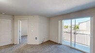 Located in Post Falls, Idaho, this one-bedroom, one-bathroom apartment offers a functional and well-designed single-floor layout. The open living room features plush carpeting and a wall-mounted HVAC unit, and flows directly onto a private balcony through a sliding glass door, providing natural light and outdoor views of the surrounding area. The entryway features durable wood-look flooring that transitions seamlessly into the main living spaces.

The galley-style kitchen is a standout feature, offering rich dark-wood cabinetry with modern hardware, light-toned countertops with generous workspace, and black appliances including a refrigerator, range, and built-in microwave. A double sink and ample cabinet storage add to the kitchen's practicality, while wood-look flooring completes the clean, cohesive look.

The bedroom is a comfortable, carpeted retreat with a ceiling fan, a natural light-filled window with vertical blinds, and a closet for storage. The full bathroom includes a combination tub and shower with a white surround, providing a clean and straightforward design. Throughout the unit, neutral wall tones and consistent finishes create a cohesive, move-in-ready atmosphere suited for comfortable everyday living.