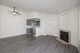 This thoughtfully designed single-story, 1-bedroom, 1-bathroom unit offers an efficient and comfortable layout with a clean, modern aesthetic throughout. Light-toned luxury vinyl plank flooring runs continuously across all rooms, complemented by crisp white walls and textured ceilings that add dimension to the space.

The open living room serves as the centerpiece of the unit, highlighted by a tile-surround corner fireplace with a built-in niche above, a sliding glass door leading to an outdoor area, and a ceiling fan. Natural light filters in through slatted blinds, creating a bright and airy atmosphere.

The kitchen is well-equipped with gray cabinetry, marble-look quartz countertops, a gas range, dishwasher, full-size refrigerator, and a deep sink. A skylight overhead floods the kitchen with additional natural light, while a pass-through peninsula connects seamlessly to the living area.

The bedroom is a comfortable, well-lit retreat featuring a window with slatted blinds and a dedicated closet for storage. The bathroom includes a full-size soaking tub and shower combination with clean white fixtures, a vanity, and coordinating flooring. A ceiling fan in the living area and a built-in wall AC unit provide year-round climate control throughout this efficiently organized home.