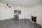 This thoughtfully designed single-story, 1-bedroom, 1-bathroom unit offers an efficient and comfortable layout with a clean, modern aesthetic throughout. Light-toned luxury vinyl plank flooring runs continuously across all rooms, complemented by crisp white walls and textured ceilings that add dimension to the space.

The open living room serves as the centerpiece of the unit, highlighted by a tile-surround corner fireplace with a built-in niche above, a sliding glass door leading to an outdoor area, and a ceiling fan. Natural light filters in through slatted blinds, creating a bright and airy atmosphere.

The kitchen is well-equipped with gray cabinetry, marble-look quartz countertops, a gas range, dishwasher, full-size refrigerator, and a deep sink. A skylight overhead floods the kitchen with additional natural light, while a pass-through peninsula connects seamlessly to the living area.

The bedroom is a comfortable, well-lit retreat featuring a window with slatted blinds and a dedicated closet for storage. The bathroom includes a full-size soaking tub and shower combination with clean white fixtures, a vanity, and coordinating flooring. A ceiling fan in the living area and a built-in wall AC unit provide year-round climate control throughout this efficiently organized home.