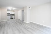 This single-floor unit offers a clean, modern aesthetic with thoughtful updates throughout. The open living area is bright and spacious, featuring light-toned luxury vinyl plank flooring that flows seamlessly through the main living spaces. Neutral warm-beige walls and clean white trim create a welcoming, airy atmosphere throughout.

The kitchen is a standout feature, outfitted with crisp white shaker-style cabinetry, granite countertops, a stainless steel sink with a modern pull-down faucet, a stainless steel dishwasher, and a contemporary gray subway tile backsplash. A louvered closet door adjacent to the kitchen provides convenient storage access in the main living area.

The bedrooms are well-proportioned, each featuring large windows fitted with blinds that allow ample natural light. Ceiling fans with light fixtures add both comfort and functionality to these rooms.

The bathroom is a refined space, showcasing large-format dark marble-look tiles lining the walls of the tub/shower surround, complemented by white marble-look tiles on the adjacent wall. The granite vanity countertop ties together the bathroom's upscale finishes. Recessed lighting adds a polished touch to the overall design. The unit combines practicality with modern style throughout its well-organized single-floor layout.
