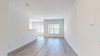 Located at 514 Ridge Dr in Union, NJ, this thoughtfully designed one-bedroom, two-bathroom residence offers a clean, modern aesthetic throughout its well-utilized single-floor layout. The open-concept living and kitchen area serves as the heart of the home, bathed in natural light from large windows that frame outdoor views. Light-toned hardwood flooring runs seamlessly through the living spaces, complementing the crisp white walls and creating an airy, cohesive atmosphere. The kitchen features dark cabinetry, granite-style countertops, stainless steel appliances, and recessed lighting, anchored by a white peninsula that connects the cooking and living areas. The spacious bedroom is highlighted by a sliding glass door that invites additional natural light and outdoor access, alongside a generously sized walk-in closet outfitted with wire shelving and hanging rods on multiple sides for ample storage. The two bathrooms are finished with neutral tile flooring and clean white fixtures, including a full bathtub with safety grab bar in one. Throughout the residence, the consistent use of light tones, modern finishes, and thoughtful spatial planning creates a bright, functional, and welcoming living environment.