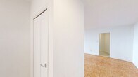 Located at 301 Dixon Road in Toronto, this well-appointed 2-bedroom, 1-bathroom unit offers a generous and thoughtfully laid-out floor plan. Warm parquet flooring flows consistently throughout the living areas and bedrooms, adding a classic, timeless character to the space. The bright and open living area is a highlight, featuring large floor-to-ceiling windows that flood the room with natural light and provide expansive outdoor views, with sliding glass doors leading directly to a private balcony. The kitchen is clean and modern, outfitted with white cabinetry, a subway tile backsplash, light tile flooring, and stainless steel appliances including a refrigerator and dishwasher. The primary bedroom is generously sized, with large windows overlooking the surrounding landscape, while both bedrooms benefit from dedicated closet spaces equipped with built-in hanging rods. The bathroom features a full soaker tub and shower combination, finished with crisp white subway tile surround and chrome fixtures. A hallway connects the rooms efficiently, contributing to a practical and comfortable flow throughout the unit. The overall aesthetic is clean, bright, and neutral, making it a versatile and move-in ready space.
