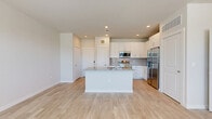 Located at 19939 Longenbaugh Rd in Houston, TX, this well-designed one-bedroom, one-bathroom residence offers a clean, modern aesthetic with thoughtful finishes throughout. The open-concept layout seamlessly connects the kitchen and living area, creating a bright and functional shared space. Light wood-style flooring flows continuously across the entire unit, enhancing the sense of openness and cohesion.

The kitchen is a standout feature, centered around a large island with a granite countertop and an undermount sink. White shaker-style cabinetry extends to the upper walls, complemented by a subtle tile backsplash and a full suite of stainless steel appliances, including a refrigerator, range, and built-in microwave. Recessed lighting illuminates the space effectively throughout.

The bedroom is a comfortable, well-proportioned room featuring a ceiling fan, natural light from multiple windows with exterior views, and direct access to a walk-in closet outfitted with wire shelving systems for organized storage.

The bathroom maintains the same refined palette, with a granite-topped vanity, white cabinetry, a large mirror, and a tub-shower combination featuring marble-style tile surround. Wood-look flooring carries through here as well, tying the space together with a clean, contemporary feel.